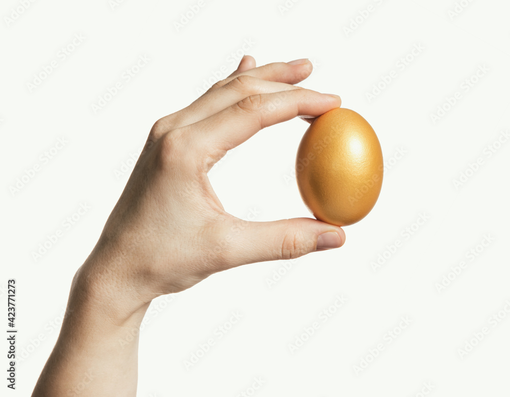 Golden egg in a woman's palm. Concept of luxury, individuality; best choice. Isolated on white. Golden egg in a woman's palm. Concept of luxury, individuality; best choice. Isolated on white.