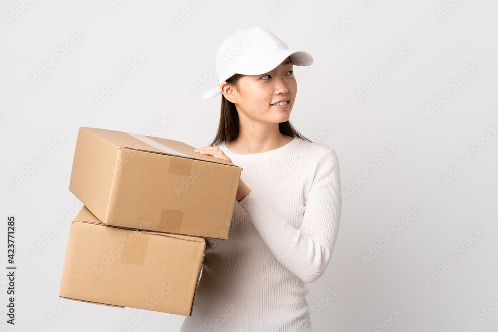 Young delivery Chinese woman over isolated white background looking to the side Young delivery Chinese woman over isolated white background looking to the side