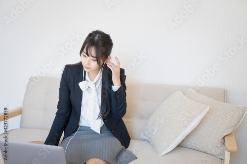 自宅でPCを見つめる女性。動画視聴、オンライン会議
