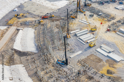 Construction of a stadium, exhibition complex, arena. Heavy machines for driving pillars work in laying the foundation building. Aerial view height. photo