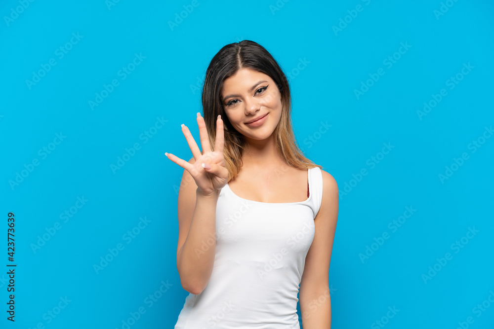 Young Russian girl isolated on blue background happy and counting four with fingers Young Russian girl isolated on blue background happy and counting four with fingers