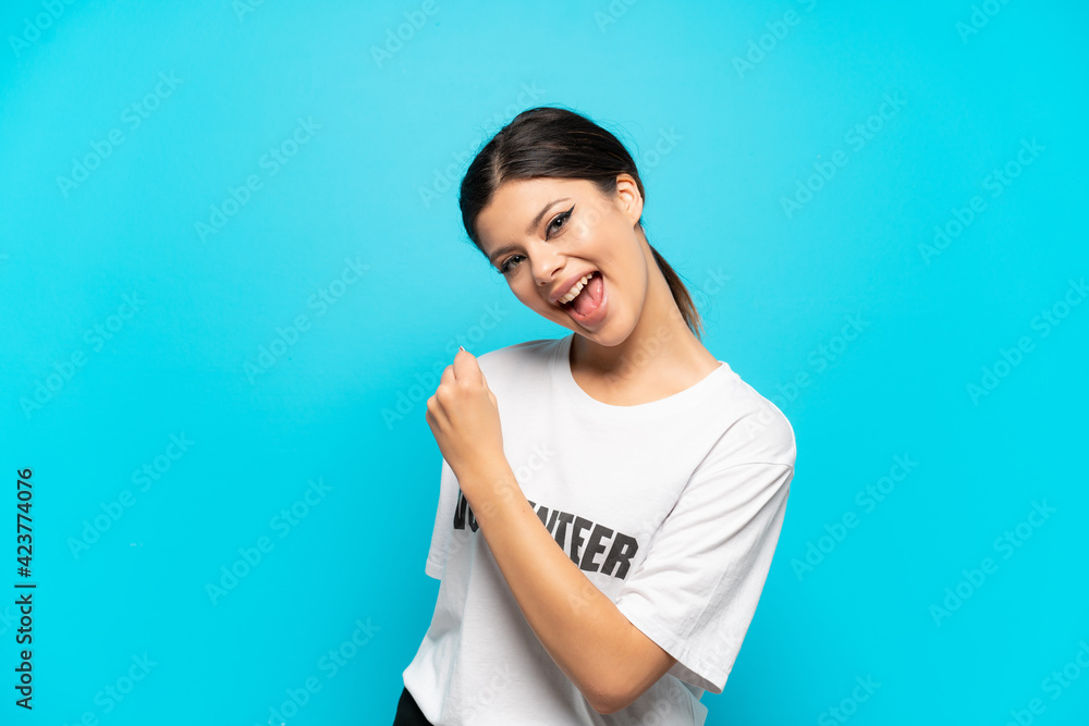 Young Russian volunteer girl isolated on blue background celebrating a victory Young Russian volunteer girl isolated on blue background celebrating a victory