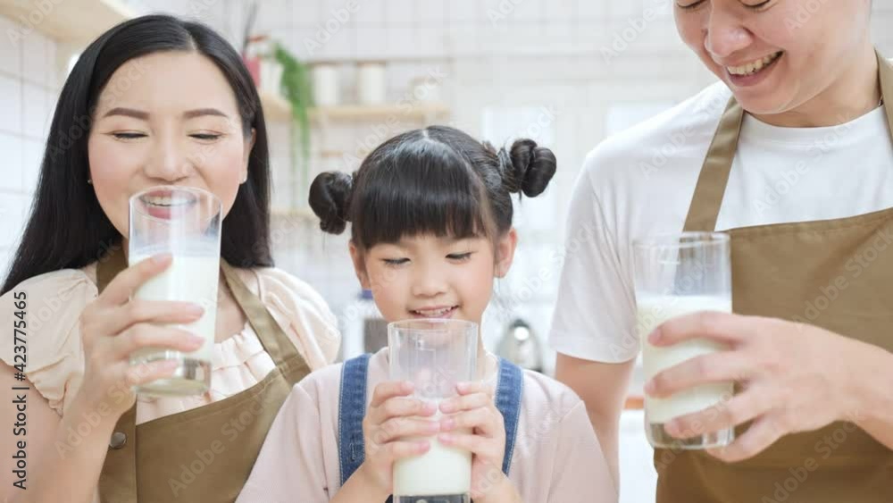 Portrait of Asian happy family drinking milk together in the kitchen. Portrait of Asian happy family drinking milk together in the kitchen.