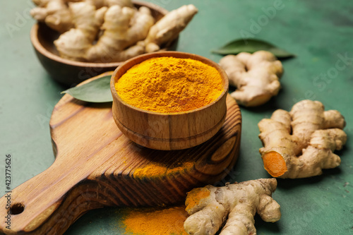 Картината върху платно Bowl with turmeric powder on color background