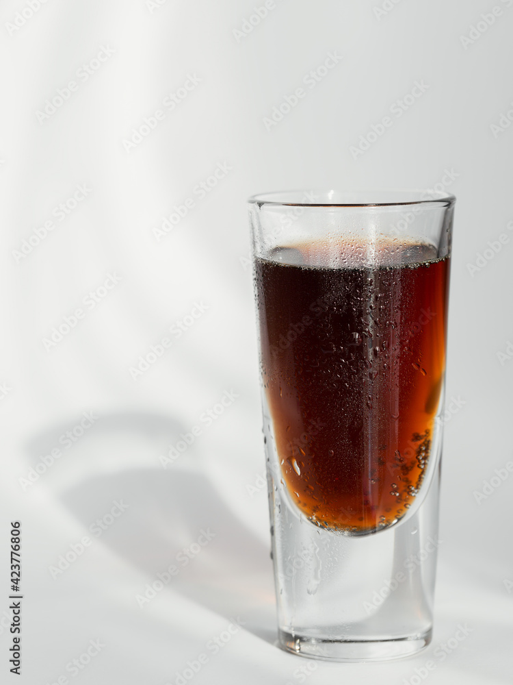 Glass of cola on a white background with reflections