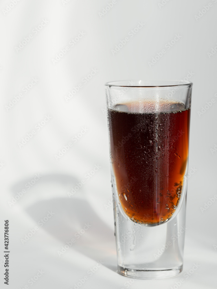 Glass of cola on a white background with reflections Glass of cola on a white background with reflections
