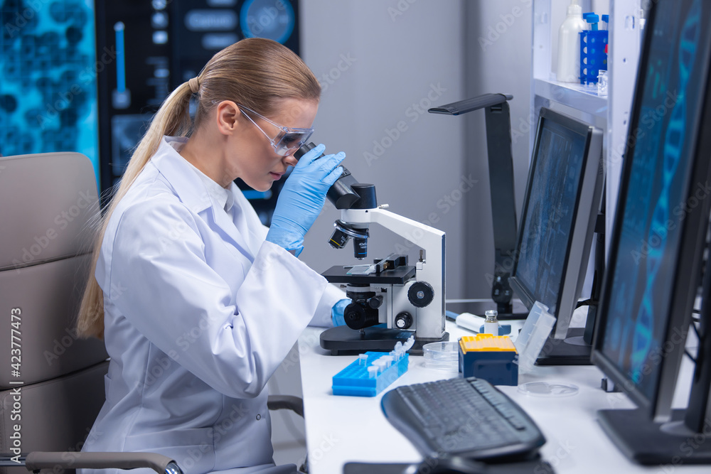 Professional female scientist is working on a vaccine in a scientific research laboratory. Genetic engineer workplace. Technology and science concept. Professional female scientist is working on a vaccine in a scientific research laboratory. Genetic engineer workplace. Technology and science concept.