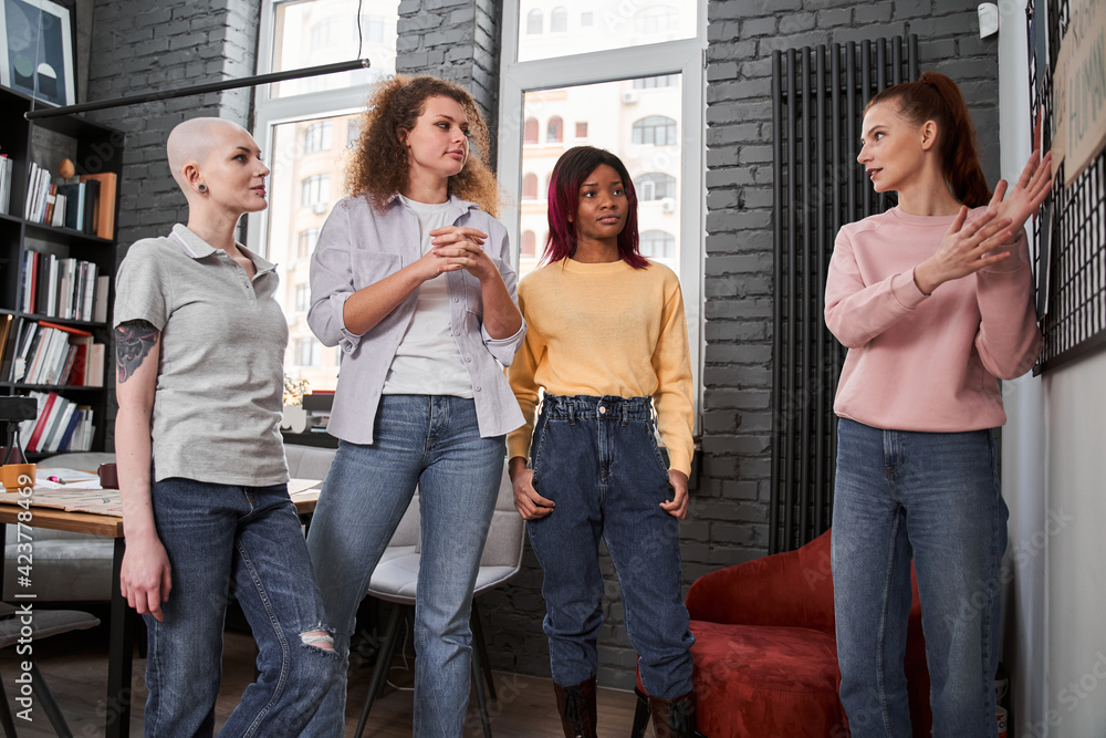 Obraz premium Girl standing near the board and discussing main topics with her girlfriends