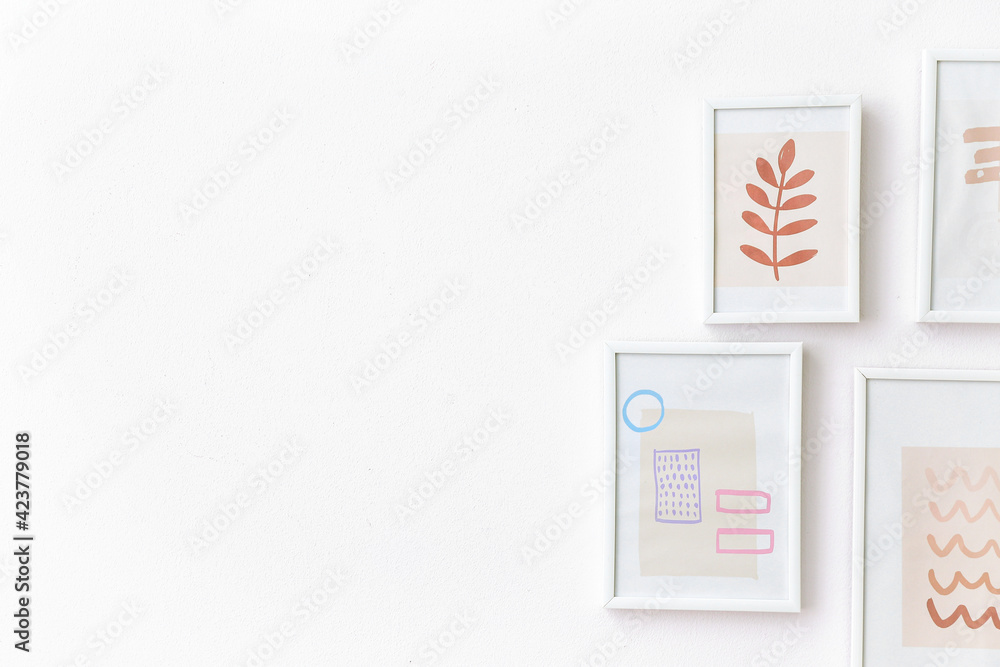 Stylish frames with pictures hanging on light wall Stylish frames with pictures hanging on light wall