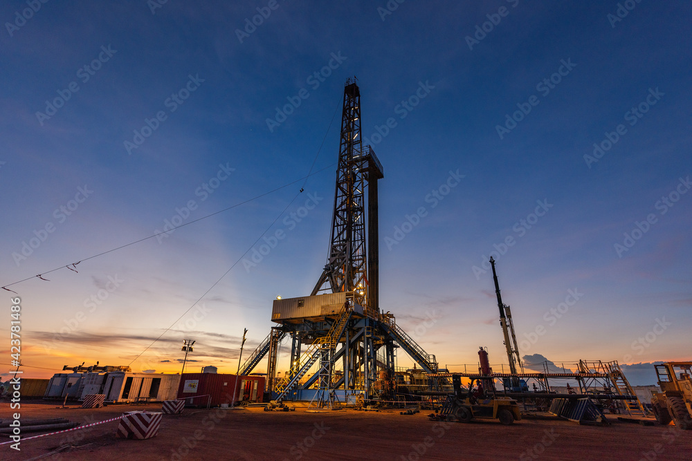 Land drilling rig in oil field during sunrise, petroleum industry