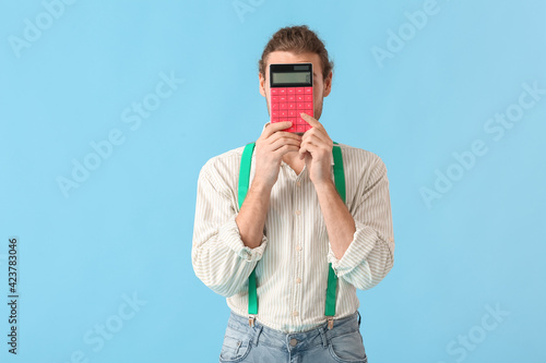 Young man with calculator o...