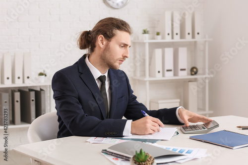 Male accountant with calcul...