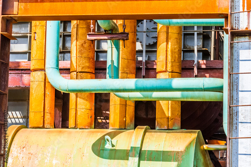 Close up image of yellow and green steel pipes in the plant. Industrial concept.
