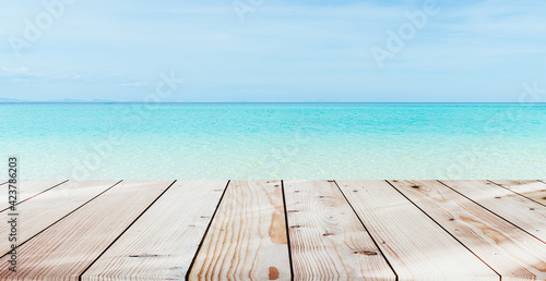 The blur cool sea background with wood floor foreground on horizon tropical sandy beach  relaxing outdoors vacation with heavenly mind view at a resort deck touching sunshine  sky surf summer clouds.