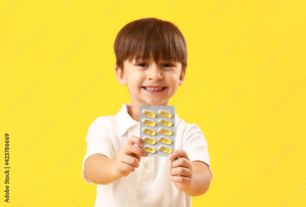 Little boy with fish oil on color background Little boy with fish oil on color background