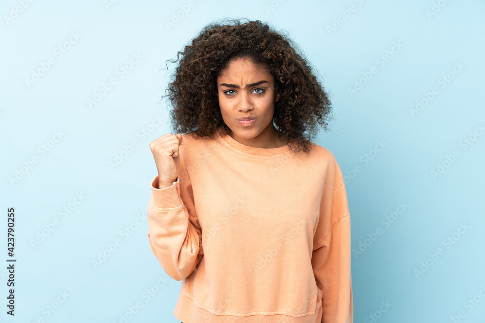 Young African American woman isolated on blue background with unhappy expression Young African American woman isolated on blue background with unhappy expression