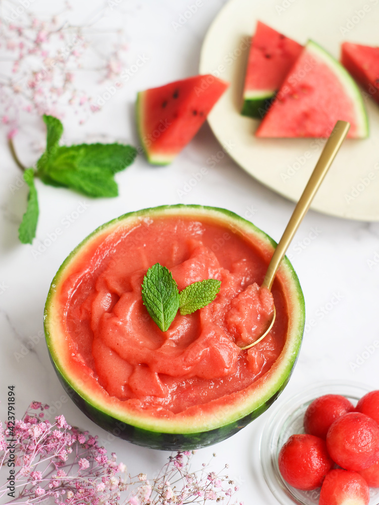 A fresh homemade watermelon sorbet in its shell decorated with mint leaves, golden spoon inside with its ball and its pieces. A perfect refreshing treat for summer. It's actually healthy, paleo&vegan A fresh homemade watermelon sorbet in its shell decorated with mint leaves, golden spoon inside with its ball and its pieces. A perfect refreshing treat for summer. It's actually healthy, paleo&vegan