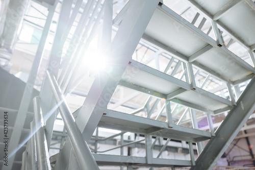 Metallic staircase painted with light gray paint. Sunlight and selected focus.