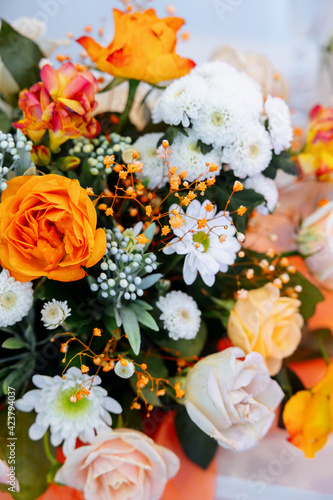 The table is decorated with orange and yellow flowers. gerbera, roses and rose mix. Gypsophila and calendula. Spring decor.