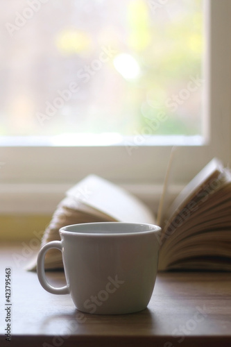 Cup of tea and coffee and open book on a table. Selective focus.
