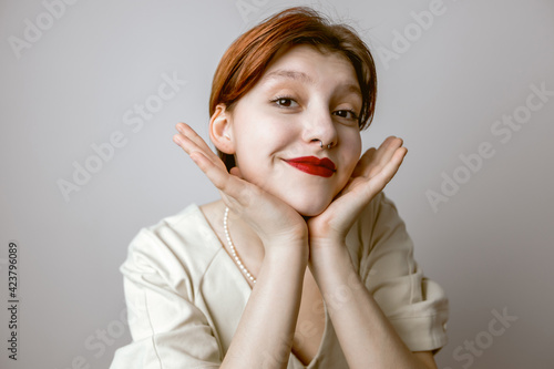 Close-up portrait of women with red lips touching face and smiling