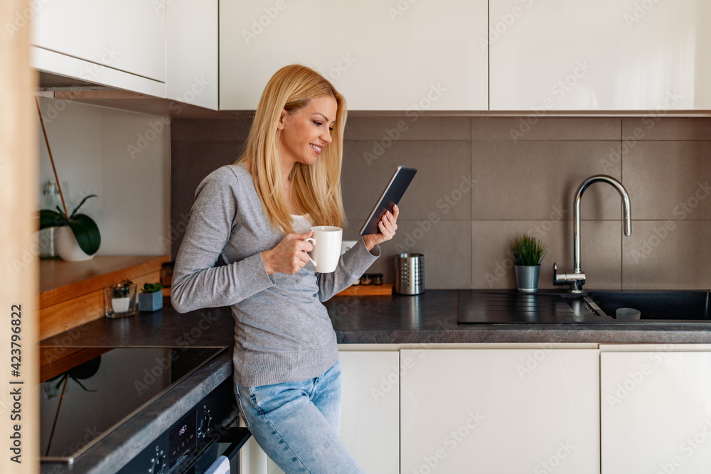 Smiling young woman using digital tablet