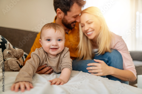 Happy mother, father and baby at home