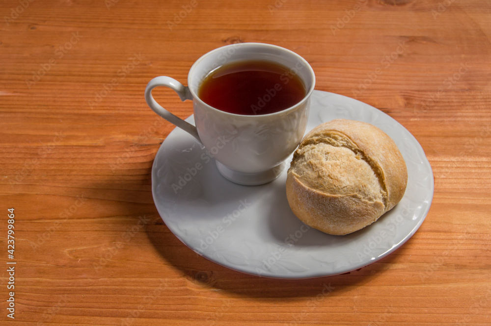 plate with cup of tea and bread, isolated on wood background. plate with cup of tea and bread, isolated on wood background.