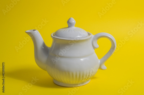 white teapot. yellow background, isolated on yellow background