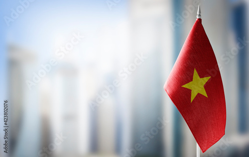 A small flag of Vietnam on the background of a blurred background