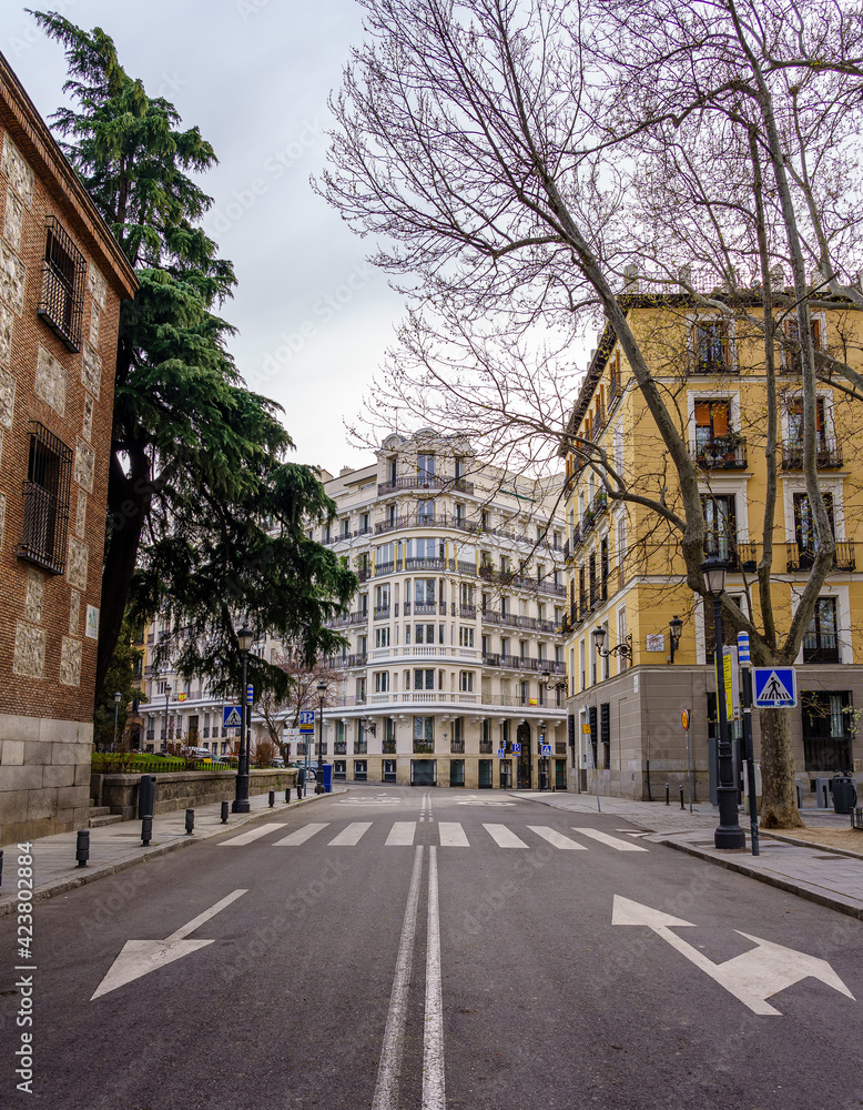 Madrid street with neoclassical buildings of different colors and typical balconies.