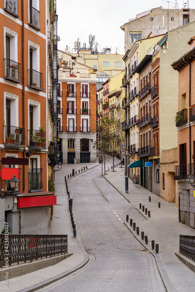 Typical Madrid street winding between buildings with windows and balconies typical of the city.