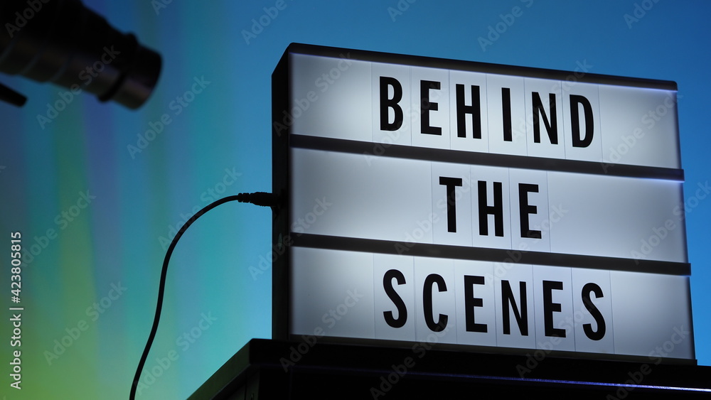 Behind the scenes letterboard text on Lightbox or Cinema Light box. Multi color LED on background. Sillhouette flash snoot hood on tripod. video production studio. Behind the scene Lightbox Behind the scenes letterboard text on Lightbox or Cinema Light box. Multi color LED on background. Sillhouette flash snoot hood on tripod. video production studio. Behind the scene Lightbox