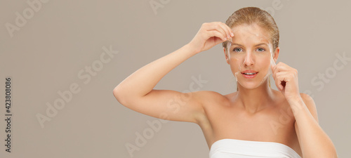 Foto Woman removing facial peel off mask