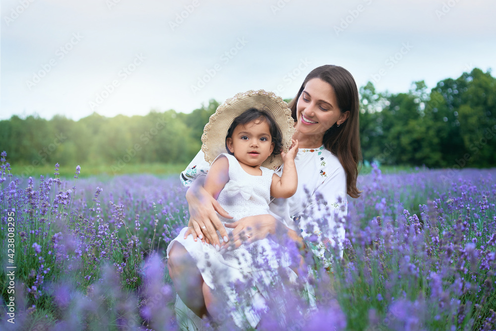 Smiling young mother posing with kid in lavender field. Smiling young mother posing with kid in lavender field.