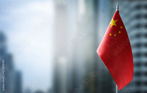 A small flag of China on the background of a blurred background