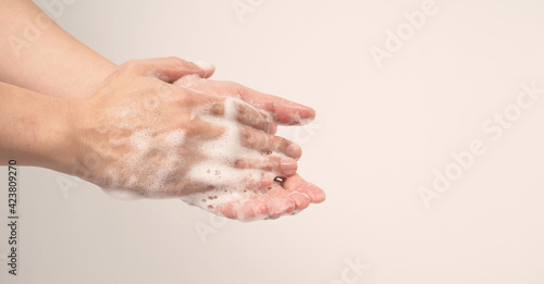 Hands washing gesture with foaming hand soap on white background.