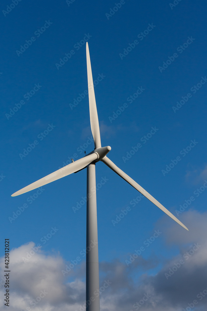 Single wind turbine rotors after a storm with a blue sky and clouds in the background Single wind turbine rotors after a storm with a blue sky and clouds in the background