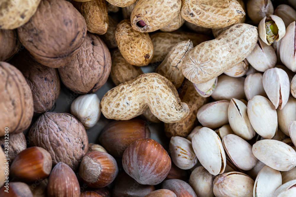 Pistachios, walnuts, hazelnuts, and peanuts in one bowl. Natural, soft light Pistachios, walnuts, hazelnuts, and peanuts in one bowl. Natural, soft light