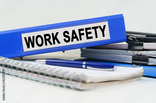 On the table are a notebook, a pen, documents and a folder with the inscription - WORK SAFETY