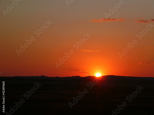 Scenic view of a sunset with bright red and orange glow at Badlands National Park in South Dakota