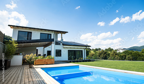 House with swimming pool outdoors in backyard garden. photo