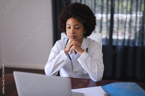 African american female doctor sitting making video call consultation