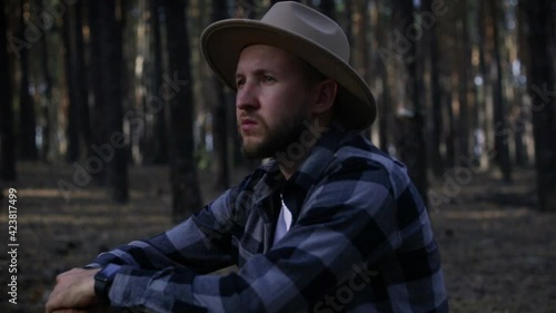 Wallpaper Mural Young man with hat resting while hiking in the mountains or forest at sunset. Torontodigital.ca