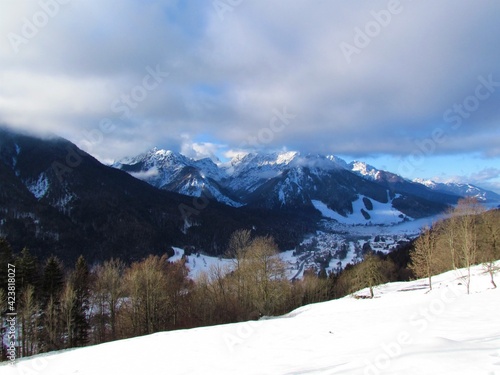 Mountain peaks above the town of Kranjska gora and Vrsic pass in Gorenjska  Slovenia in winter and clouds in the sky above
