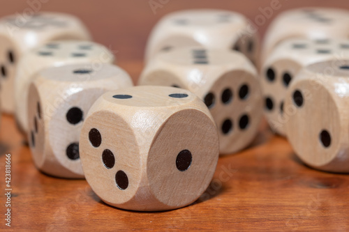 Wooden dice for board game on wooden table.