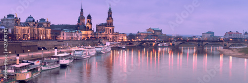 Night panorama of Dresden Old town with reflections in Elbe river and passenger ships