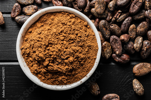 Roasted cocoa beans and cocoa powder in bowl