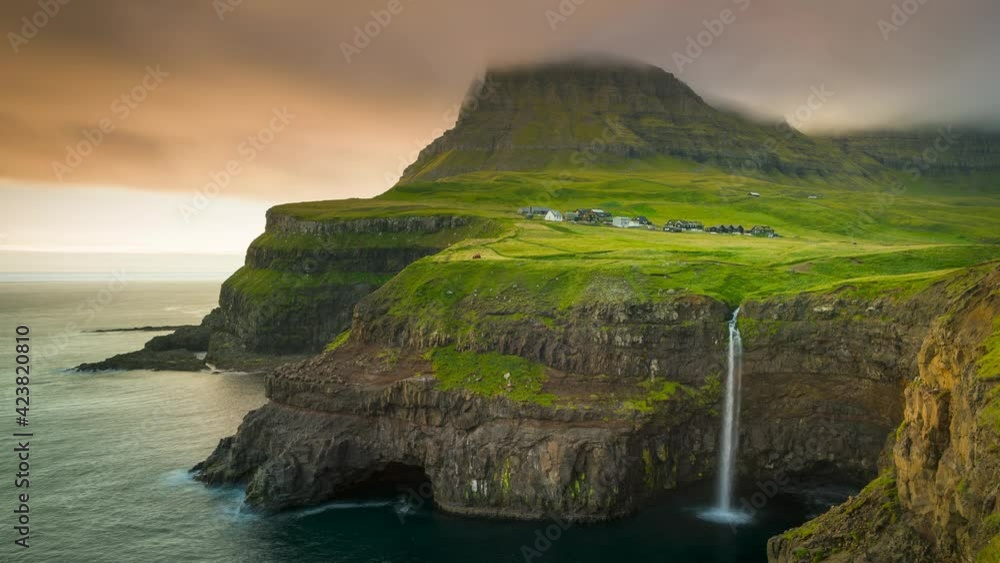 Time lapse of sunset over waterfall Mulafossur and village Gasadalur on Vagar, fast moving colourful clouds over mountain and ocean, Faroe Islands
Time lapse of sunset over waterfall Mulafossur and village Gasadalur on Vagar, fast moving colourful clouds over mountain and ocean, Faroe Islands