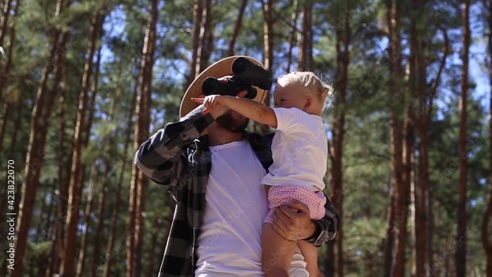Man with his child while walking in the woods.
